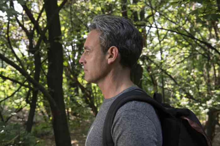 Profile of a man with a backpack in the woods
