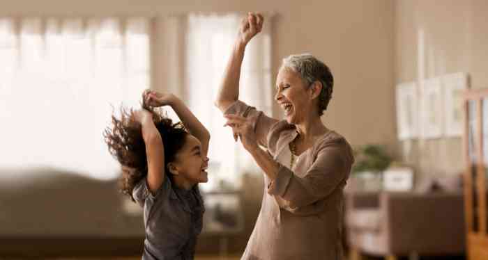 Grandmother and granddaughter laughing and dancing