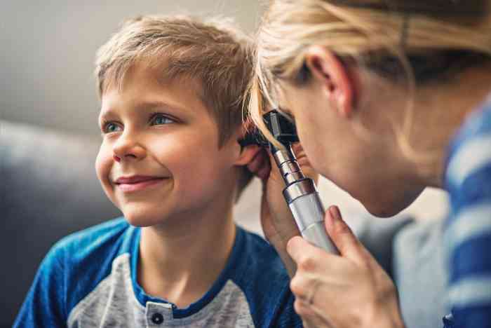 A kid has his hearing checked by a hearing professional
