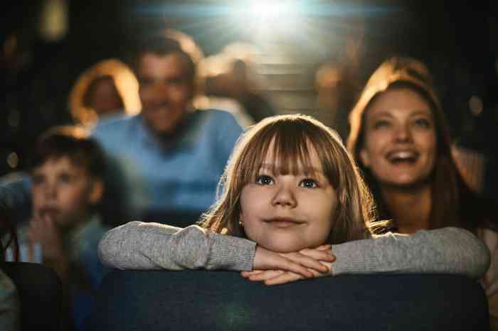 A young girl watching a movie at the cinema