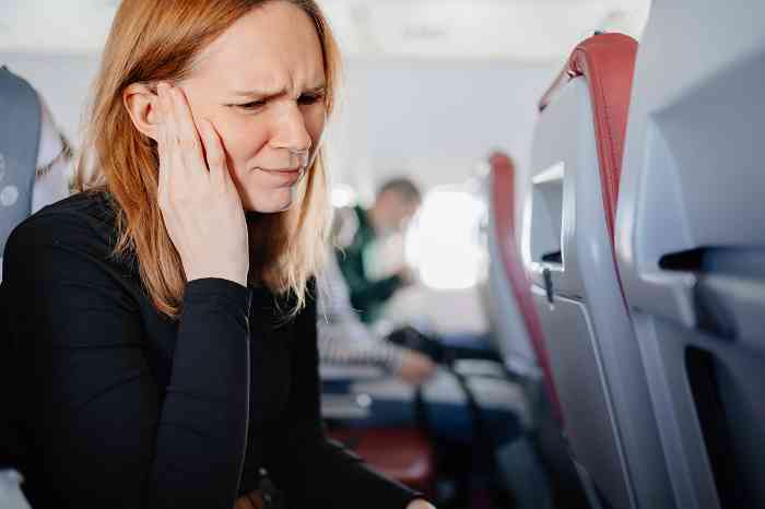 woman on airplane with ear pain