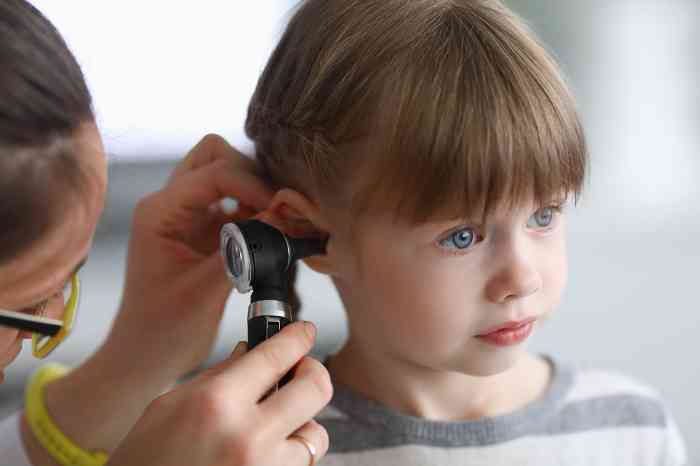 Doctor checking baby's ear