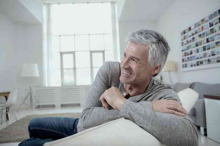 A man smiling on a sofa enjoying his time in his living room