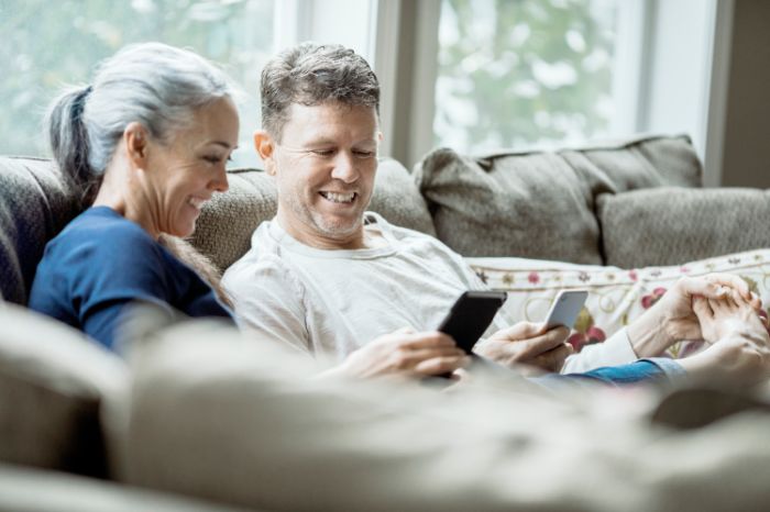 Couple on couch looking at phones