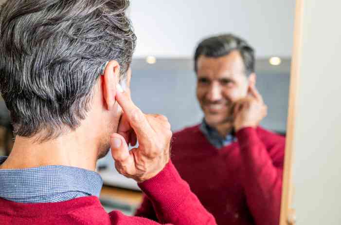 Male client with hearing aid smiling