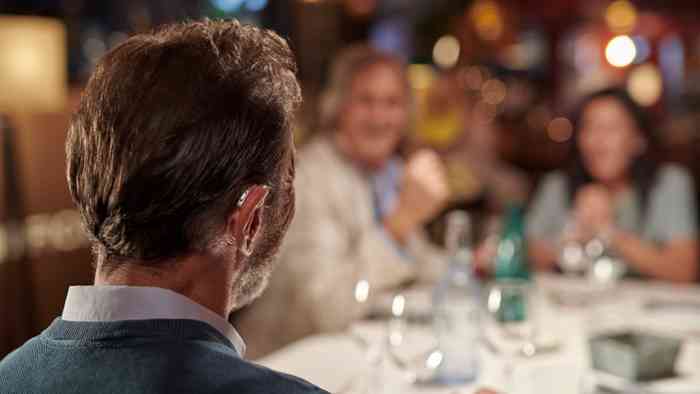 Man wearing a hearing aid at the restaurant
