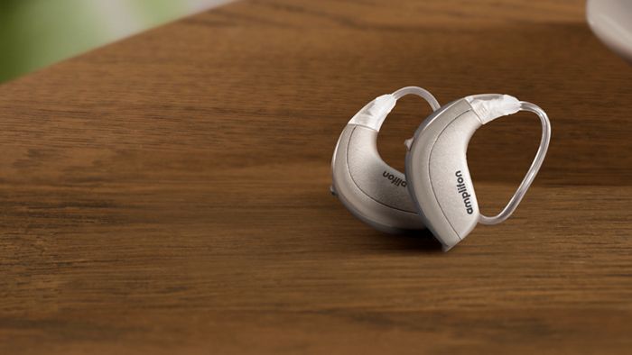 Une personne en train de nettoyer son appareil auditif avec une brosse