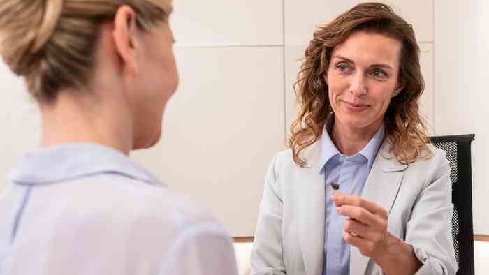 Audiologue présente une aide auditive à une cliente