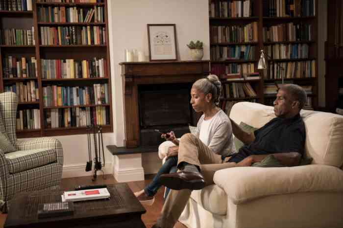 Senior couple with almost invisible hearing aids on their sofa