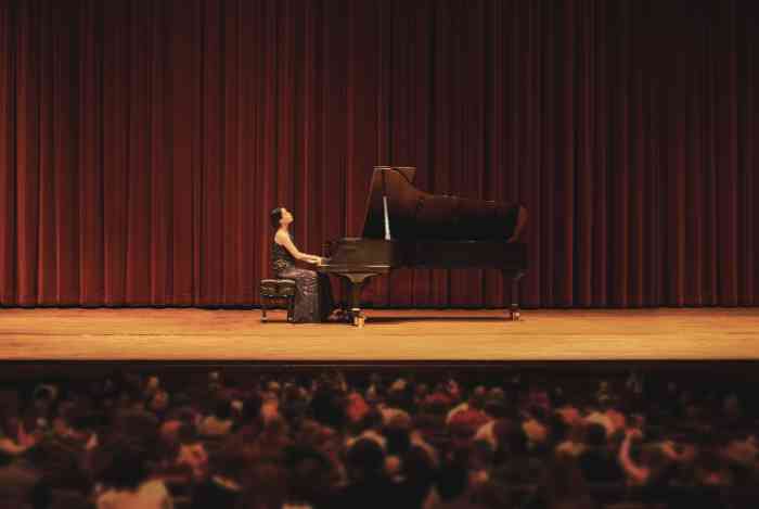 vrouw speelt piano met concert oordoppen