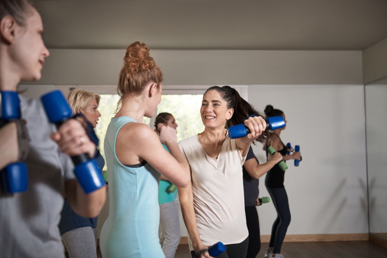 groupe de femmes s’entraînant ensemble à la salle de sport.