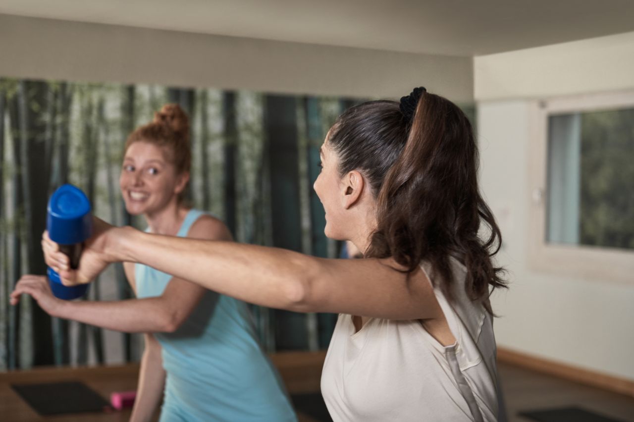 Gruppe von Frauen trainiert gemeinsam im Fitnessstudio.