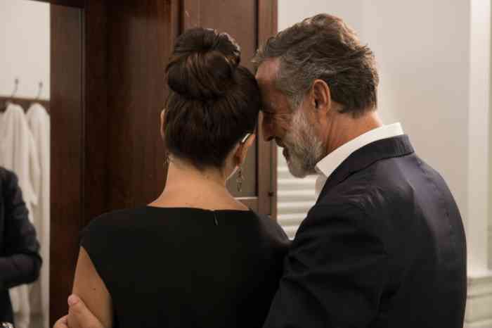 A couple is ready for a night out. She's elegantly wearing a hearing aid