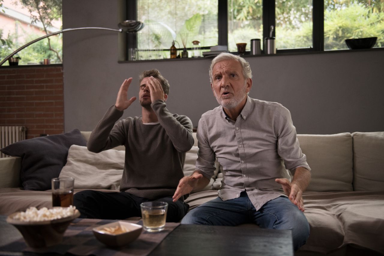 grand-père et petit-fils regardant la télévision ensemble.