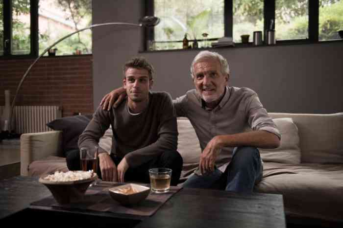 Grandfather and grandson watching tv on a sofa 