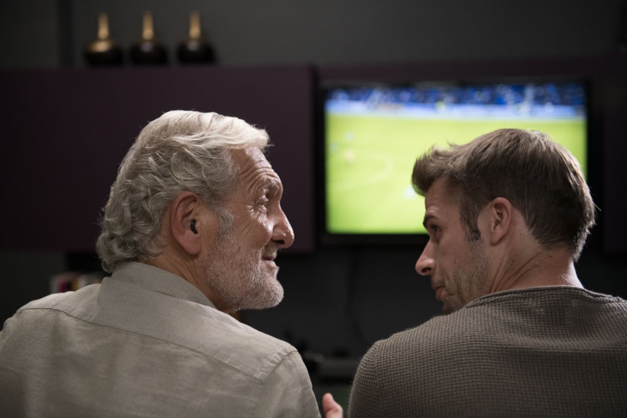 Un grand-père et son petit-fils regardant un match de football à la télévision