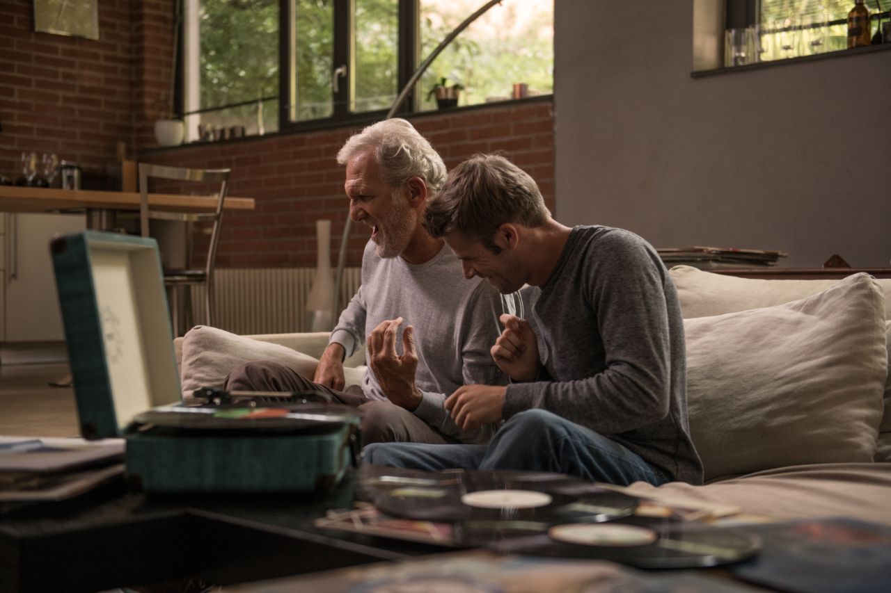 nonno e nipote che usano un giradischi insieme.