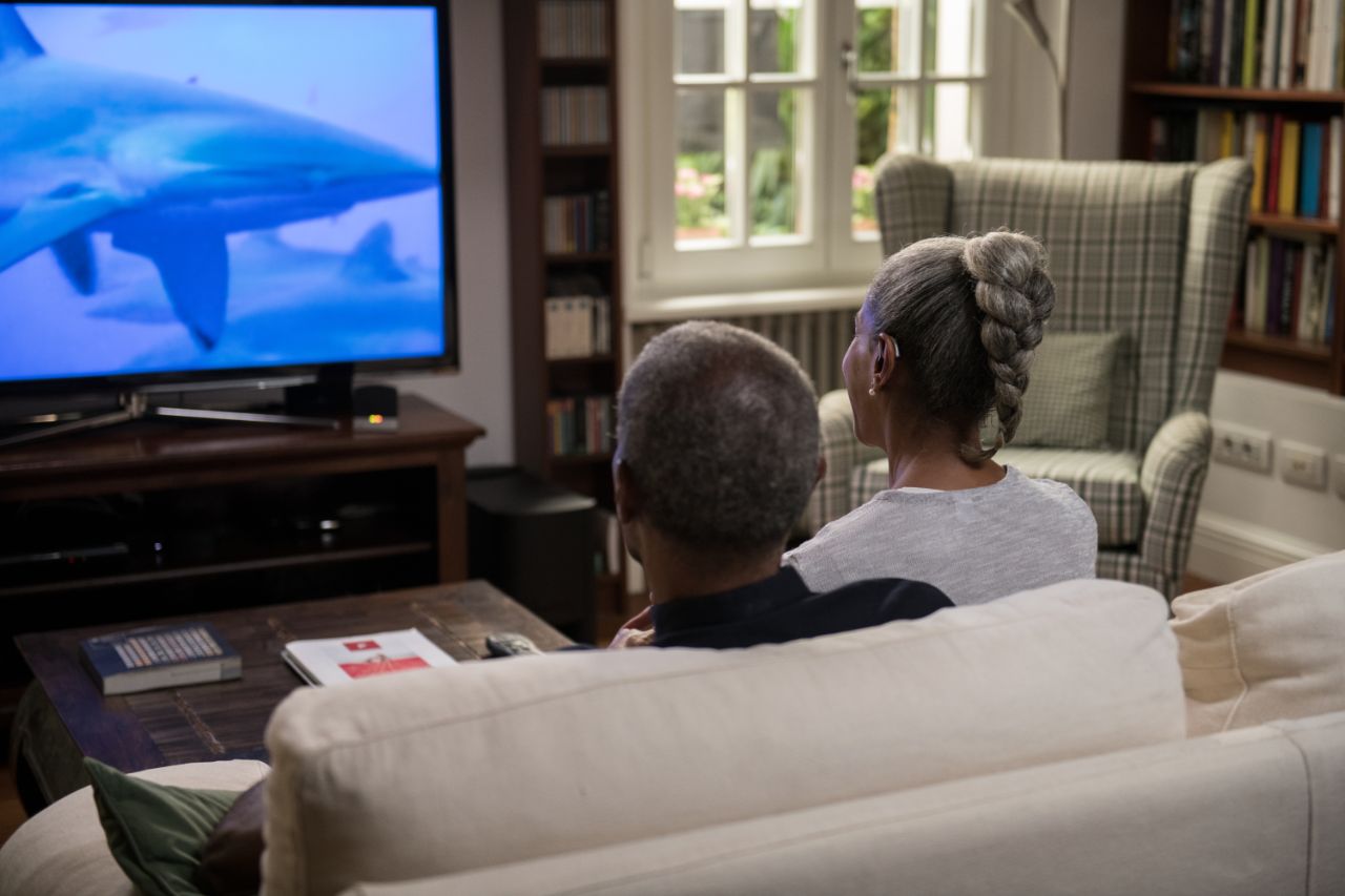 A couple watching TV on a sofa