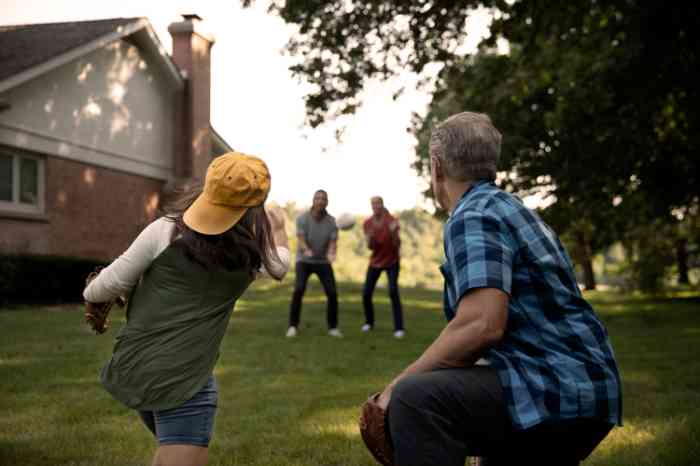 Nonno con apparecchio acustico che riceve palla da baseball