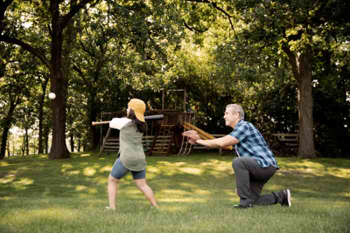 Un homme et sa fille jouent au baseball dans un parc.