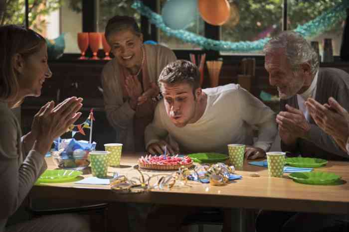 Family celebrating birthday party with a cake