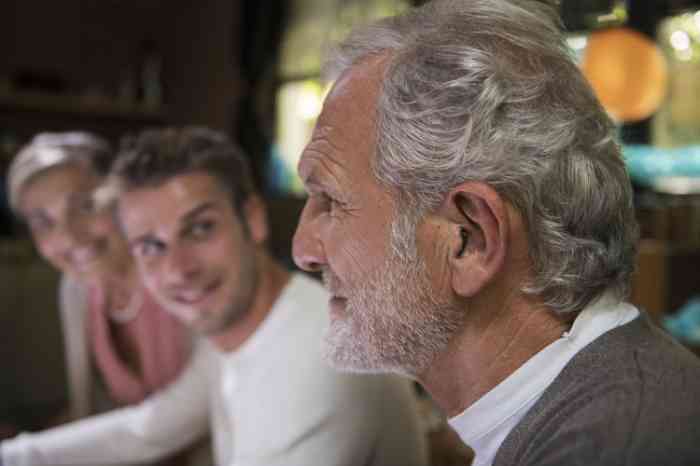 Profile of a senior man with invisible hearing aid