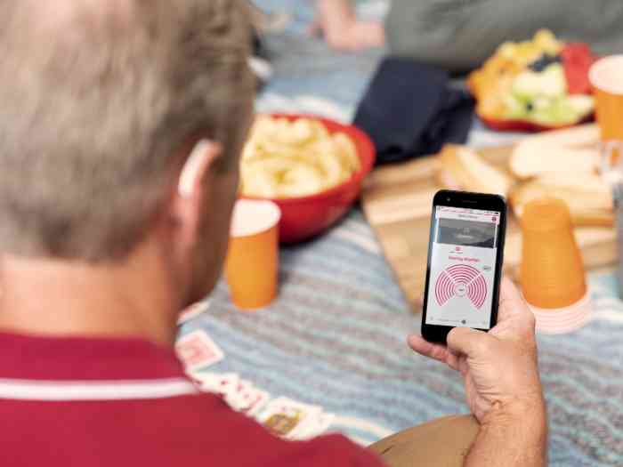 Man gebruikt Amplifon app tijdens picnic