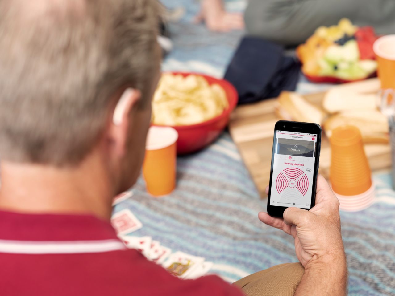 famiglia che utilizza un telefono durante un picnic.