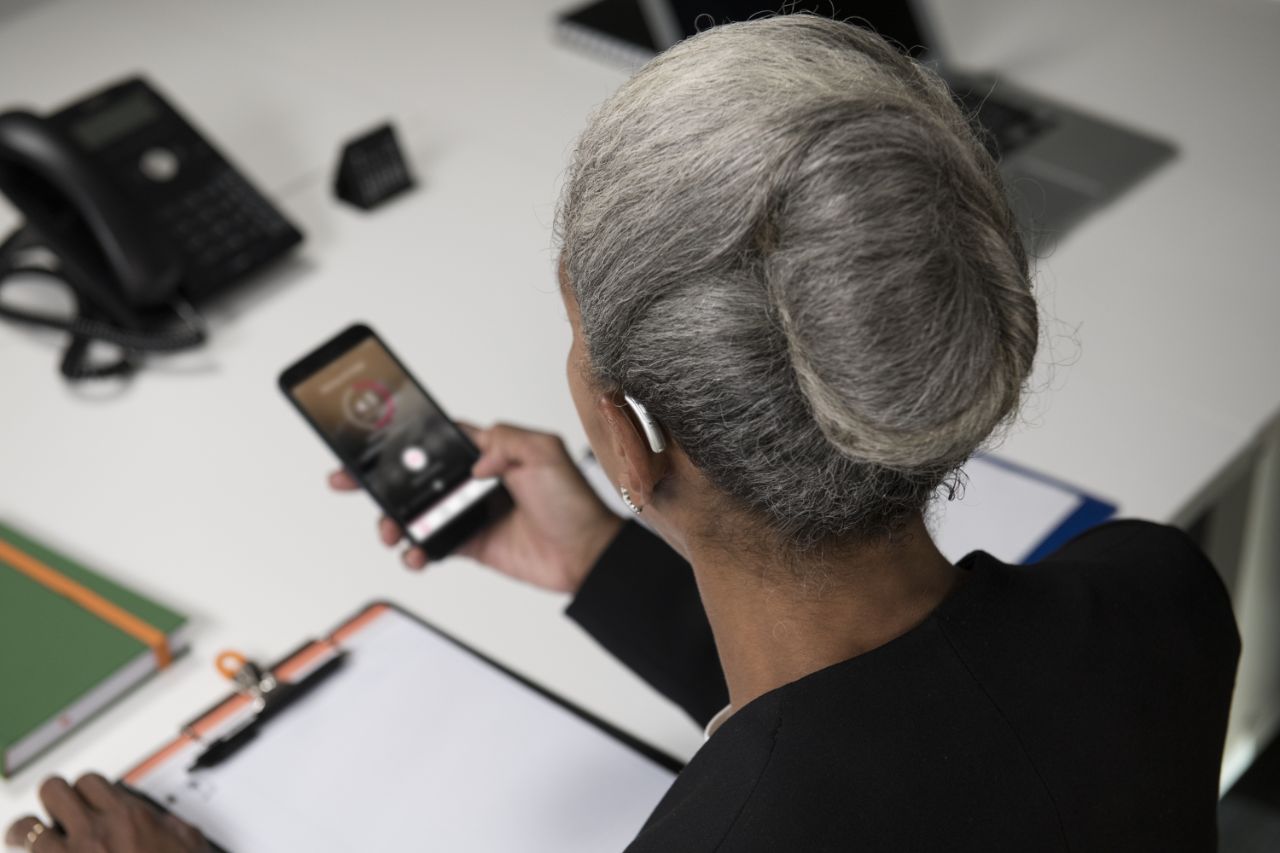 Femme d'affaires utilise l'application Amplifon