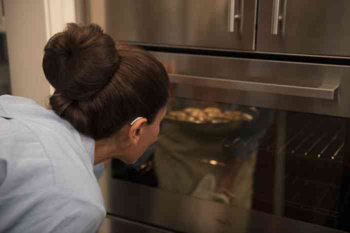woman cooking something in the oven.
