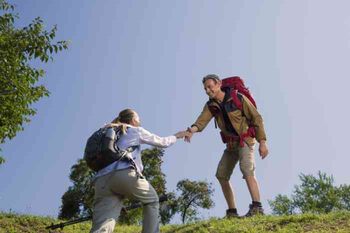 A couple with backpacks hiking on the mountain