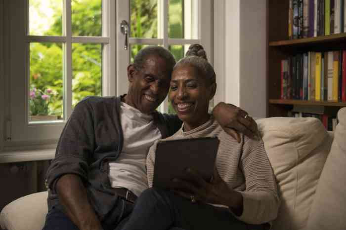 Senior couple with their hearing aids connected to their tablet