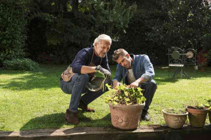 Grandfather and grandson gardening and taking care of their plants