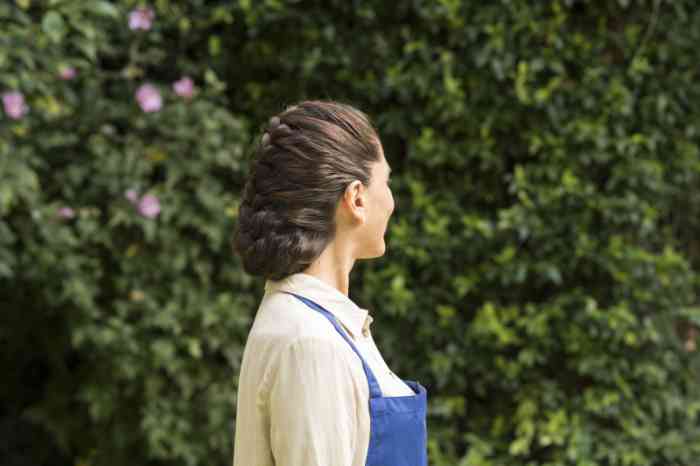 Frau trägt Hinter-dem-Ohr Hörgerät bei Gartenarbeit