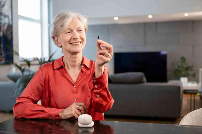 A woman looking at her hearing aid