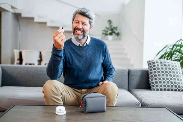 Man with hearing aids in hand