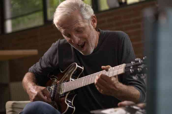 A senior playing guitar