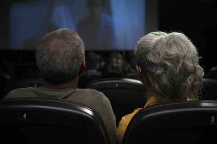 A woman wearing her hearing aid at the cinema