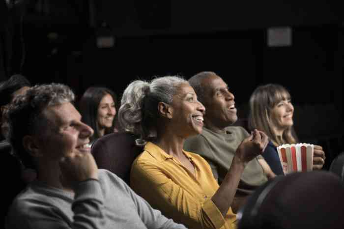 A woman enjoying a movie with her husband thanks to her almost invisible hearing aid