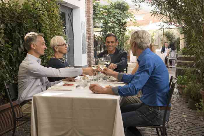 A group of friends making a toast sitting at a restaurant table