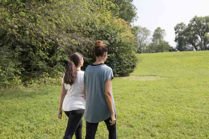 Two young girls walking in a park