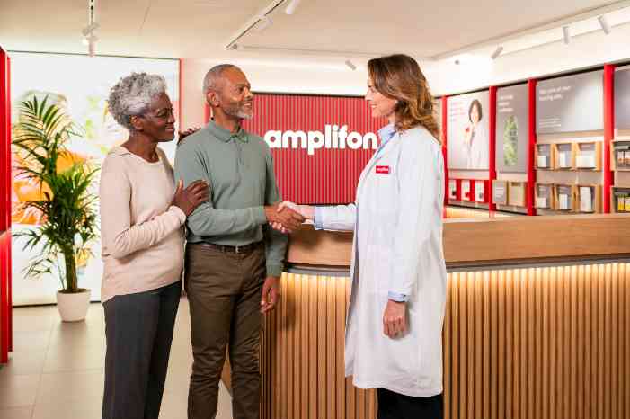 Afro couple handshaking with a female audiologist