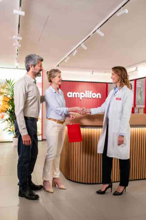 Une spécialiste d'Amplifon salue un client dans l'un des magasins