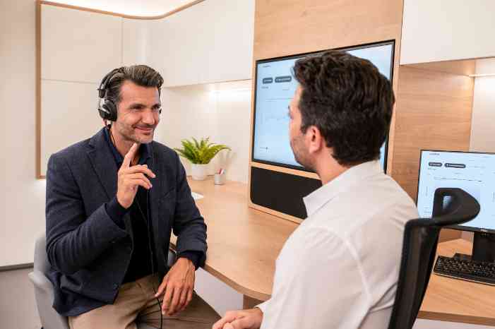  Un homme passe un test auditif dans un cabinet avec un audioprothésiste. 