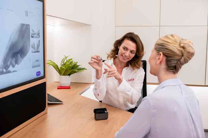 Un senior se fait conseiller par une audioprothésiste dans un centre Amplifon