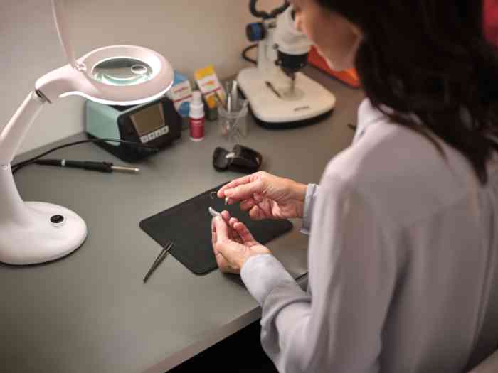 Audiologiste vérifiant une aide auditive