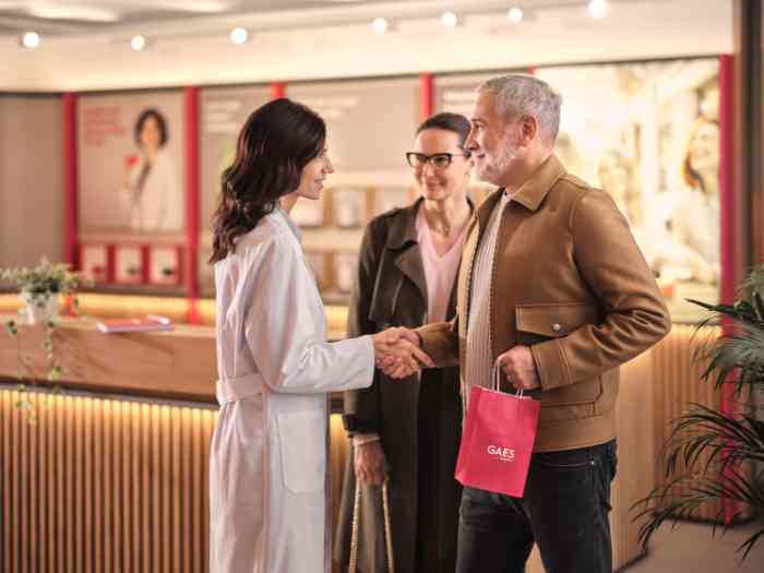 couple saluant l'audiologiste en blouse dans un magasin Gaes.