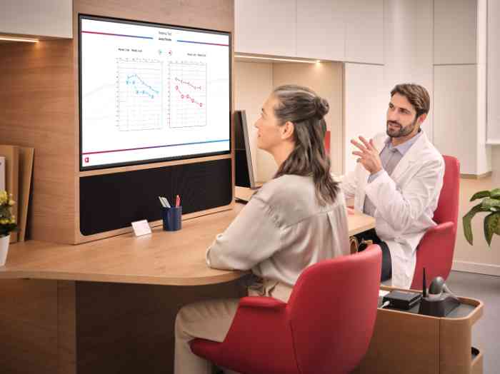 Frau bespricht die Ergebnisse des Tests mit einem Audiologen im Laborkittel.