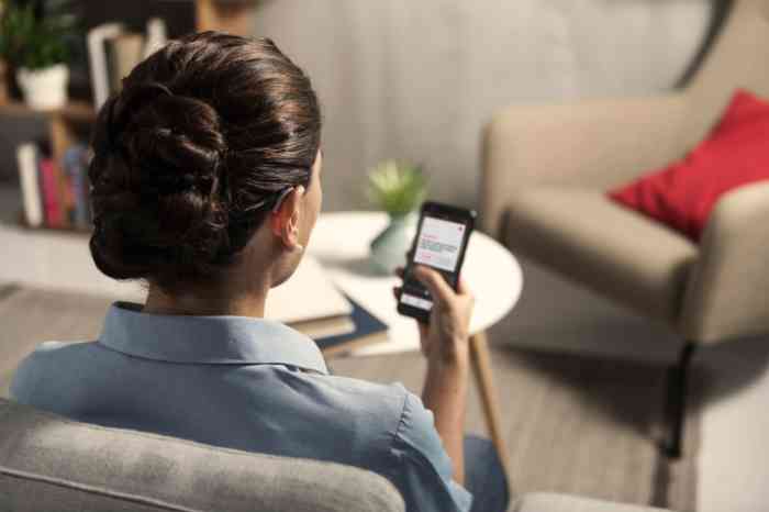 A couple with a tablet smiling on their sofa