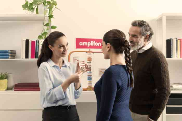 Amplifon Audiologist showing her clients Amplifon products